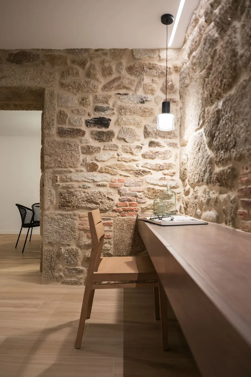 Espace bureau sur mesure à Polignac — maçonnerie ancienne en granit avec inclusions de terre cuite, plan de travail suspendu en chêne clair